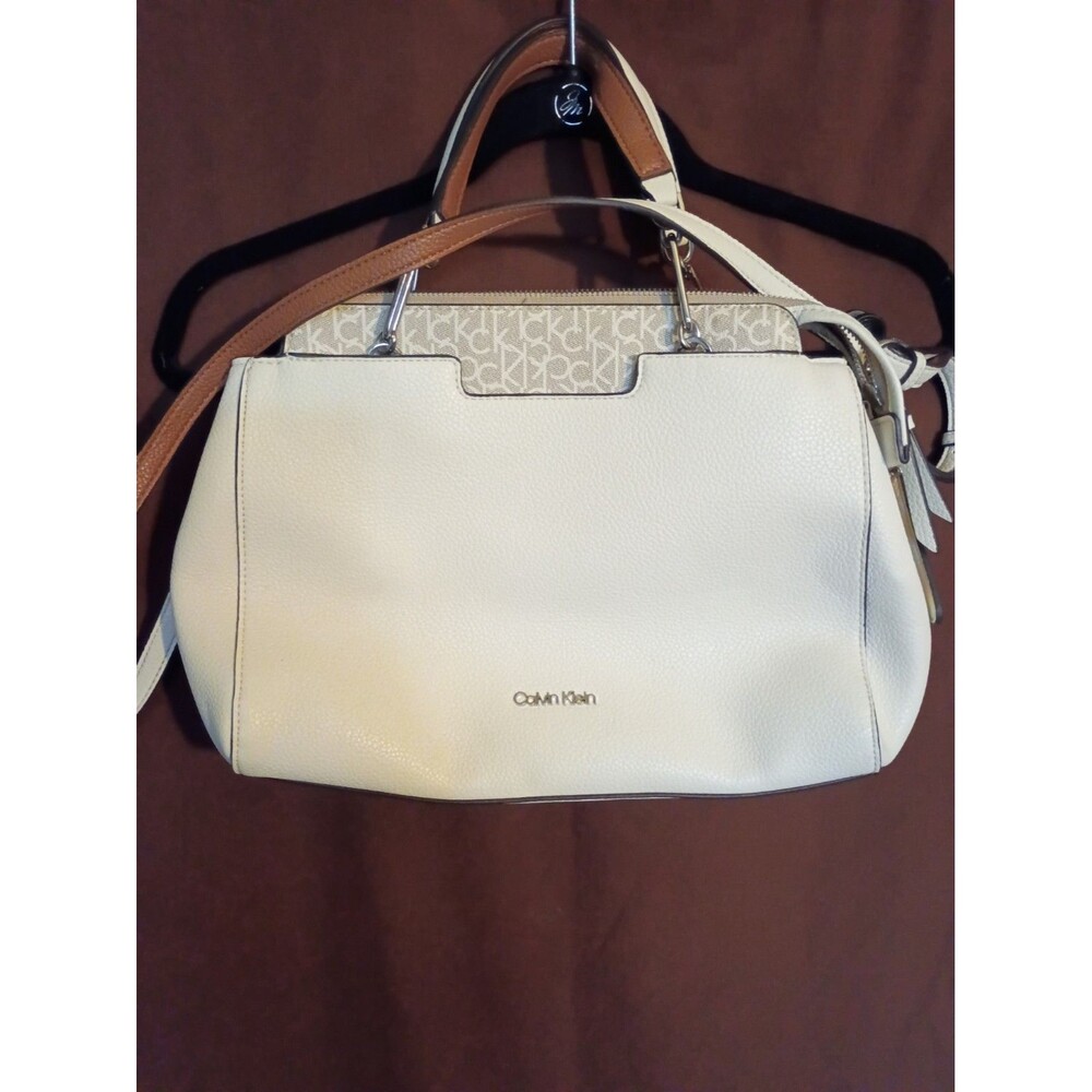 Calvin Klein Edie Triple Compartment Satchel, featuring a cream-colored main...